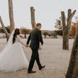 Groom And Bride Walking Together. Bride Wearing Lace Ball Gown Called Mallory Dawn By Maggie Sottero
