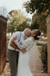 Bride Wearing Crepe Wedding Dress Called Dionne By Rebecca Ingram With Groom Kissing Her Neck