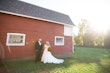 Groom with Bride in Front of Barn Wearing Wedding Dress Called Savannah by Maggie Sottero.