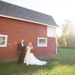 Groom with Bride in Front of Barn Wearing Wedding Dress Called Savannah by Maggie Sottero.