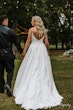 Bride Wearing Aline Satin Wedding Gown Called Scarlet By Maggie Sottero Walking Hand In Hand With Groom