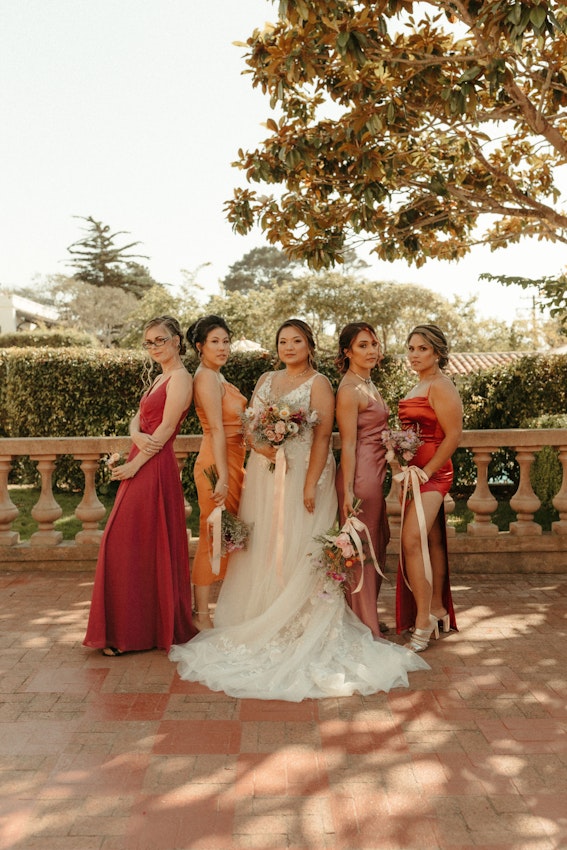 Bride with bridesmaids wearing affordable A-Line floral motif wedding dress.