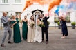 Bride wearing Tuscany Lynette kissing her husband in front of her bridal party