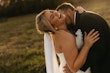 Bride Wearing Lace Mermaid Wedding Gown Called Toccara By Maggie Sottero With Groom Kissing Her Neck