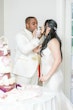 Newlyweds sipping champagne together their arms crossed.