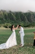 Bride wearing Winter wedding dress by Maggie Sottero puts necklace on her husband