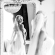 Bride looking back in to large shabby chic mirror wearing wedding dress called Juanita.