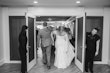 Bride wearing Bronson by Sottero and Midgley walking into her reception with her husband