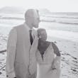 Bride wearing Johanna Lane by Maggie Sottero hugging her husband on the beach