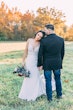 Bride Wearing Crepe Sheath Wedding Dress Called Alda By Rebecca Ingram Leaning On Groom