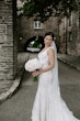 Bride Wearing Lace Backless Wedding Dress Called Chauncey By Sottero And Midgley Holding A White Bouquet