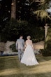 Bride wearing Scarlet by Maggie Sottero holding hands with her husband