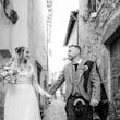 Bride wearing Iris wedding dress by Rebecca Ingram walking with her husband