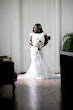 Bride wearing lace modest wedding dress with cap sleeves.