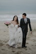 Bride wearing Frederique wedding gown by Maggie Sottero walking with groom