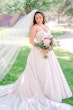 Bride In White Wedding Dress Named Shasta By Sottero and Midgley With Veil And Pink Flowers