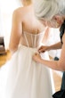 Bride wearing Nisha by Maggie Sottero being buttoned up