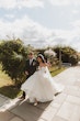 Bride wearing Derrick by Maggie Sottero walking with her husband