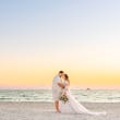 Bride Wearing Boho Sleeved Wedding Dress Called Quintyn By Maggie Sottero With Groom On A Beach With A Beautiful Sunset