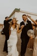 Bride Wearing Simple Fit-and-Flare Wedding Dress Called Fernanda By Maggie Sottero Walking Away With Groom