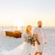 Bride Wearing Boho Sleeved Wedding Dress Called Quintyn By Maggie Sottero Walking With Groom On The Beach
