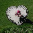 Bride Wearing Gothic Black Lace Wedding Dress Called Tristyn By Maggie Sottero With Dress Shaped As A Heart Holding Groom