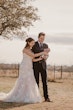 Bride wearing Bridget by Maggie Sottero opening a bottle with her husband