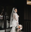 Bride Wearing Lacey Sheath Long Sleeve Wedding Dress Called Francesca By Maggie Sottero Showing Back Veil