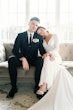 Bride wearing Fernanda wedding dress by Maggie Sottero sitting with her husband