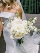 Bride Wearing Simple Fit And Flare Wedding Dress Called Mitchell Marie By Maggie Sottero Holding A White Bouquet