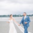 Bride Wearing Boho Sheath Wedding Dress Called Marisol By Rebecca Ingram Walking On The Beach With Groom