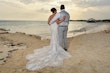 Bride wearing Franklynn by Sottero and Midgley on the beach with her husband