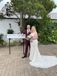 Bride wearing wedding dress called Daxton stood with groom next to Gretna Green sign.