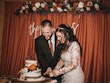 Bride Wearing Lacey Sheath Long Sleeve Wedding Dress Called Francesca By Maggie Sottero Cutting Cake With Groom