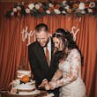 Bride Wearing Lacey Sheath Long Sleeve Wedding Dress Called Francesca By Maggie Sottero Cutting Cake With Groom