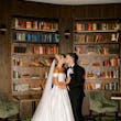 Bride wearing Zinaida by Maggie Sottero kissing her husband in a library