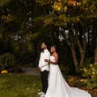 Bride Wearing Simple Fit and Flare Wedding Dress Called Anniston Lane Holding Groom In A Green Garden