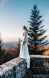 Bride Wearing Simple Long Sleeve Wedding Dress Called Bethany By Rebecca Ingram On A Stone Fence