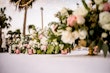 Pink and ivory flowers and pink tea light holders on centre of table at wedding party.