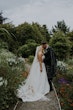 Bride Wearing Sparkly Aline Wedding Dress Called Anniston Kissing Groom In A Garden