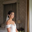Bride Wearing Simple Off-the-shoulder Wedding Dress Called Josie By Rebecca Ingram Holding White Rose Bouquet
