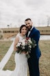 Bride And Groom Standing Together. Bride Wearing Halter Wedding Dress With Lace Motifs Called Kevyn By Sottero And Midgley