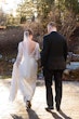 Bride Wearing Boho Sleeved Wedding Dress Called Drita By Maggie Sottero Walking With Groom