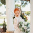 Bride Wearing Lace Long-Sleeve Wedding Gown Called Raphael By Maggie Sottero With Bouquet
