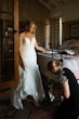 Bride Wearing Lace Mermaid Wedding Gown Called Toccara By Maggie Sottero Getting Her Shoes On With A Bridesmaid