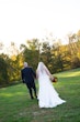 Groom Holding Hands with Bride in Wedding Dress Called Savannah by Maggie Sottero.