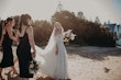 Bride Wearing Off-The-Shoulder Lace Wedding Dress Called Carson By Sottero And Midgley Walking On The Beach With Bridesmaids