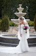 Bride Wearing Boho Sleeved Wedding Dress Bronson By Sottero And Midgley Standing By A Fountain