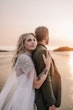 Bride wearing Summer wedding dress by Maggie Sottero behind the groom