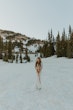 Bride in snow wearing lacy wedding dress called Tina Dawn.